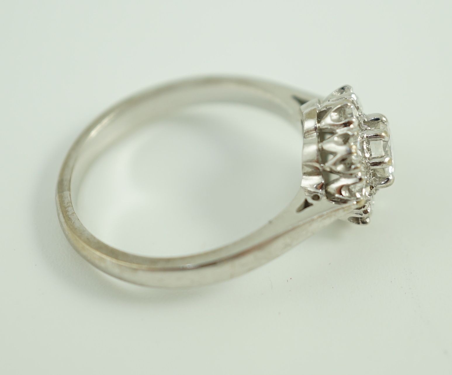 A modern 18ct white gold and nine stone diamond set flower head cluster ring